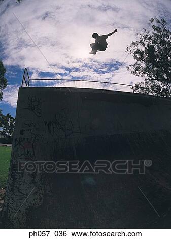 Stock Photograph - In-line skater performing stunt in mid-air . Fotosearch