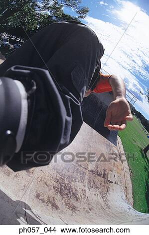Picture - In-line skater performing stunt on ramp, mid-air. Fotosearch
