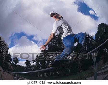 In-line skater performing stunt on railing View Large Photo Image Stock Image - In-line skater performing stunt on railing. Fotosearch