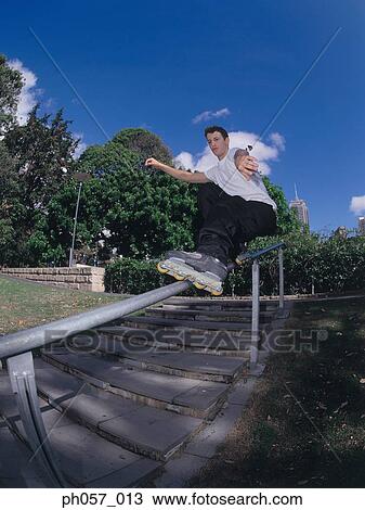 In-line skater performing stunt on railing View Large Photo Image Stock Image - In-line skater performing stunt on railing. Fotosearch