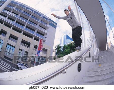In-line skater performing stunt on railing View Large Photo Image Stock Image - In-line skater performing stunt on railing. Fotosearch