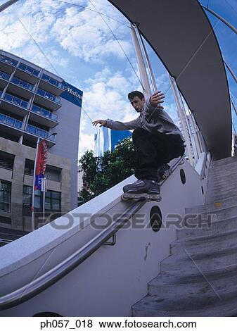 In-line skater performing stunt on railing View Large Photo Image Stock Photo - In-line skater performing stunt on railing. Fotosearch