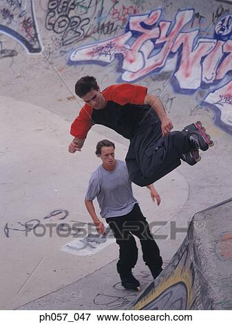 In-line skater performing stunt on ramp, mid-air View Large Photo Image Stock Photo - In-line skater performing stunt on ramp, mid-air. Fotosearch