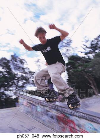 In-line skater performing stunt on railing View Large Photo Image Stock Photo - In-line skater performing stunt on railing. Fotosearch