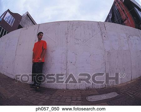 In-line skater standing against wall View Large Photo Image Stock Image - In-line skater standing against wall. Fotosearch