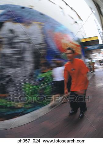 Picture - Young man inline skating on road (blurred motion) . Fotosearch