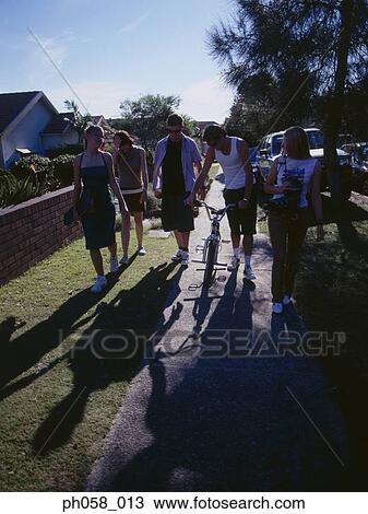 Friends walking on sidewalk View Large Photo Image Stock Image - Friends walking on sidewalk. Fotosearch