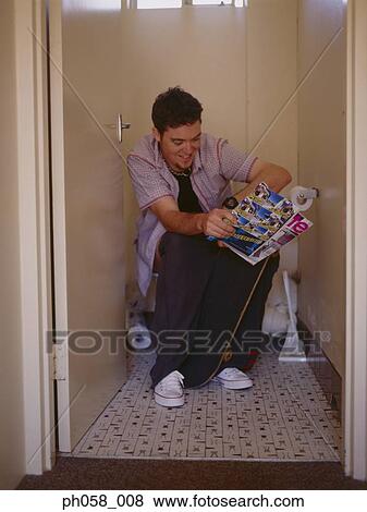 Man sitting on toilet holding comic, smiling View Large Photo Image Stock Photo - Man sitting on toilet holding comic, smiling. Fotosearch