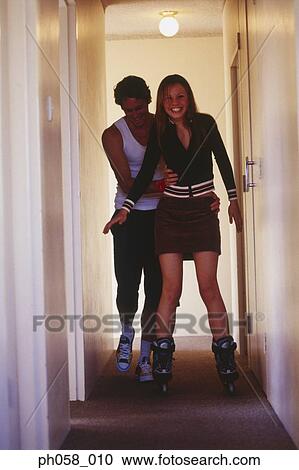Teenage girl learns skating, boy supports her from behind View Large Photo Image Stock Image - Teenage girl learns skating, boy supports her from behind. Fotosearch
