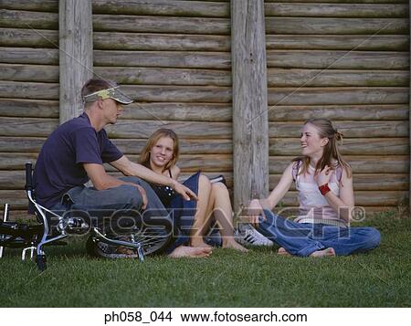 Teenagers sitting together on grass talking View Large Photo Image Picture - Teenagers sitting together on grass talking . Fotosearch