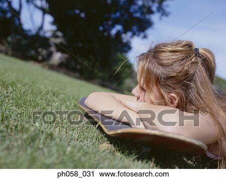 Young woman resting on skateboard View Large Photo Image Stock Image - Young woman resting on skateboard . Fotosearch