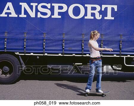 Young woman skateboarding beside a truck View Large Photo Image Stock Photo - Young woman skateboarding beside a truck. Fotosearch