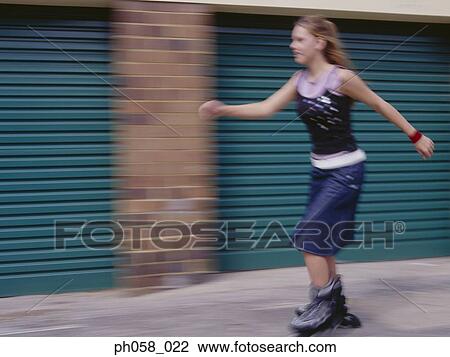 Young woman skating on pavement View Large Photo Image Stock Image - Young woman skating on pavement. Fotosearch