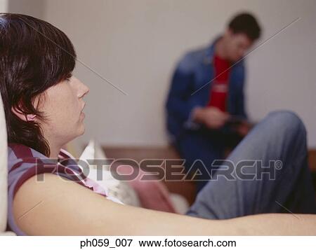 Couple sitting in the room, focusing young woman View Large Photo Image Stock Photo - Couple sitting in the room, focusing young woman. Fotosearch