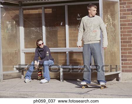 Stock Photo - Couple waiting at bus stand. Fotosearch
