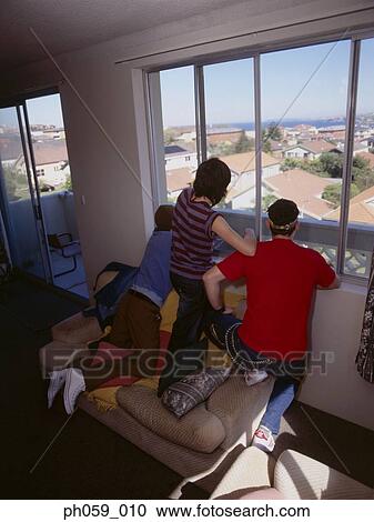 Stock Image - Friends looking out of window. Fotosearch