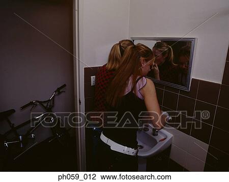 Young women applying make-up in restroom View Large Photo Image Stock Image - Young women applying make-up in restroom . Fotosearch