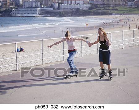 Stock Image - Young women on skateboards and inline skates. Fotosearch