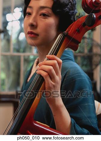 Stock Image - Japanese woman in kimono holding double bass . Fotosearch
