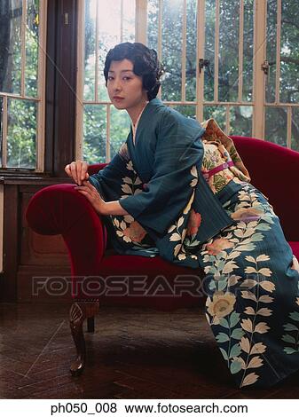 Japanese woman in kimono sitting on sofa View Large Photo Image Stock Photo - Japanese woman in kimono sitting on sofa. Fotosearch