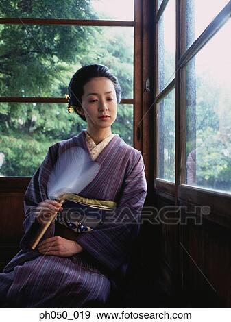 Stock Photo - Japanese woman in kimono, sitting on floor. Fotosearch