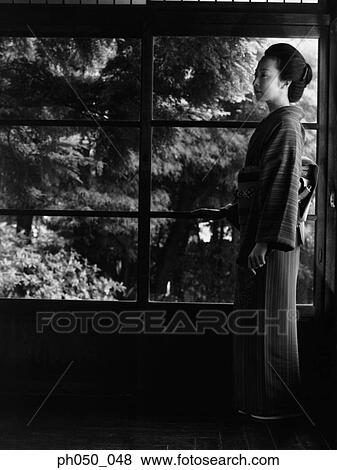 Japanese woman in kimono, standing by the window View Large Photo Image Stock Photo - Japanese woman in kimono, standing by the window. Fotosearch