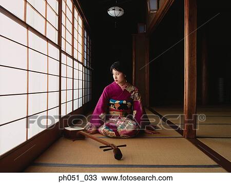 Stock Image - A young woman in kimono and 'samisen'. Fotosearch