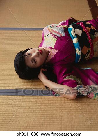Stock Photograph - Close-up portrait of a woman in kimono lying on floor . Fotosearch