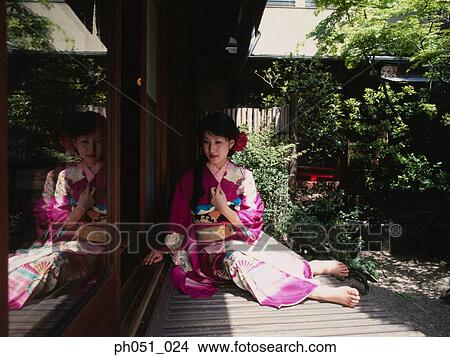 Picture - Japanese woman in kimono sitting on doorway. Fotosearch