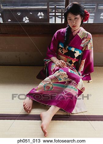 Stock Image - Japanese woman in kimono, sitting on floor. Fotosearch
