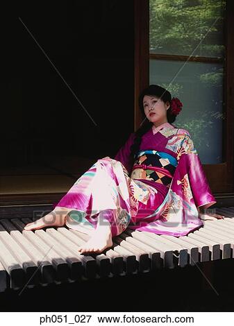 Stock Photo - Japanese woman in kimono sitting on doorway. Fotosearch