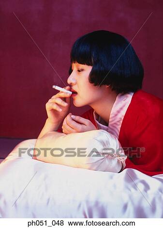 Japanese woman in kimono smoking a cigarette View Large Photo Image Stock Photo - Japanese woman in kimono smoking a cigarette. Fotosearch