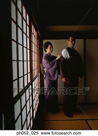 Japanese woman in kimono removing man's jacket View Large Photo Image Stock Photography - Japanese woman in kimono removing man's jacket. Fotosearch
