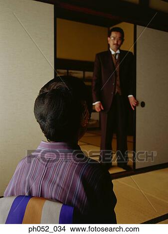 Japanese woman sitting in room, man standing by door View Large Photo Image Picture - Japanese woman sitting in room, man standing by door. Fotosearch