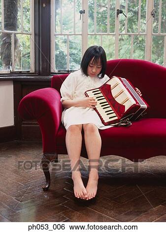 Girl playing accordion on sofa View Large Photo Image Stock Photograph - Girl playing accordion on sofa. Fotosearch