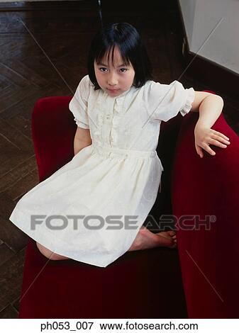Girl sitting on sofa View Large Photo Image Stock Photo - Girl sitting on sofa. Fotosearch