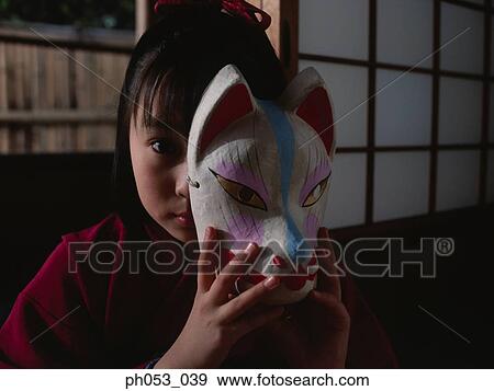 Stock Photo - Japanese girl in kimono holding a mask. Fotosearch