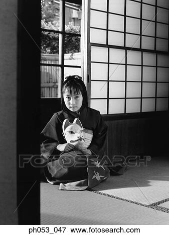 Stock Photo - Japanese girl in kimono holding a mask. Fotosearch