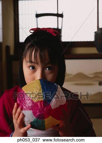 Stock Photo - Japanese girl in kimono holding paper ball. Fotosearch
