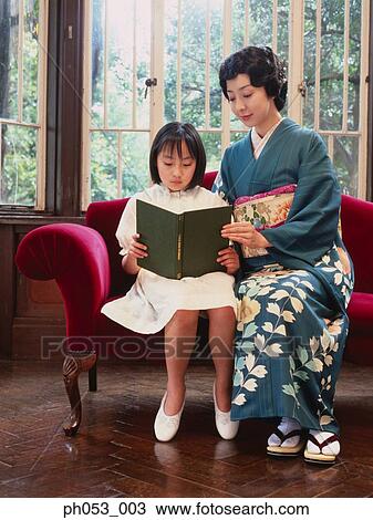 Stock Image - Mother and daughter reading . Fotosearch