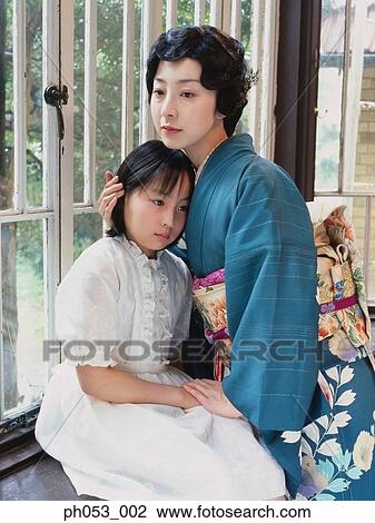Mother embracing daughter in room, portrait View Large Photo Image Stock Image - Mother embracing daughter in room, portrait . Fotosearch