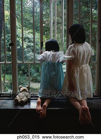 Two girls leaning on sill, looking out of window, rear view View Large Photo Image Stock Photography - Two girls leaning on sill, looking out of window, rear view . Fotosearch