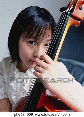 Stock Photo - Young girl holding bass instrument . Fotosearch