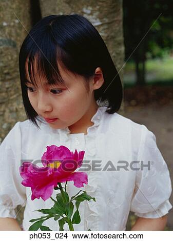 Picture - Young girl holding flower, close-up, portrait. Fotosearch