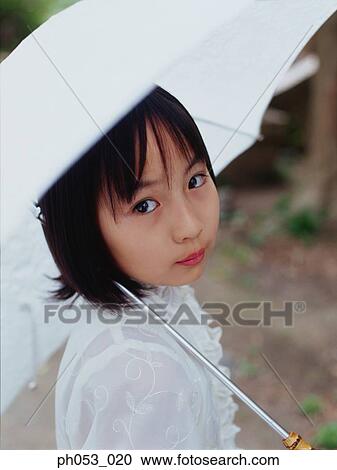 Stock Image - Young girl holding umbrella, portrait. Fotosearch