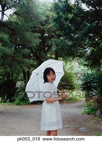 Young girl holding umbrella, portrait View Large Photo Image Stock Photo - Young girl holding umbrella, portrait. Fotosearch