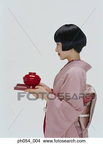 Picture - Japanese woman in kimono serving tray a bowl of soup. Fotosearch