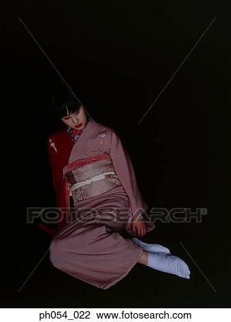 Stock Image - Japanese woman in kimono sitting on floor. Fotosearch