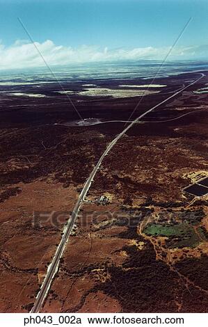 Stock Image - USA, Hawaii, Big Island, highway on lava field, aerial view . Fotosearch