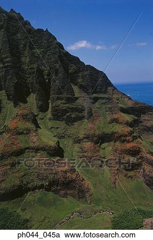 Stock Image - Aerial view of a mountainous cliff bordering the ocean, Kauai, Hawaii. Fotosearch